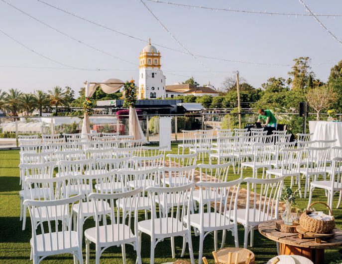 Sillas blancas de ceremonia en la azotea con vistas a Sevilla