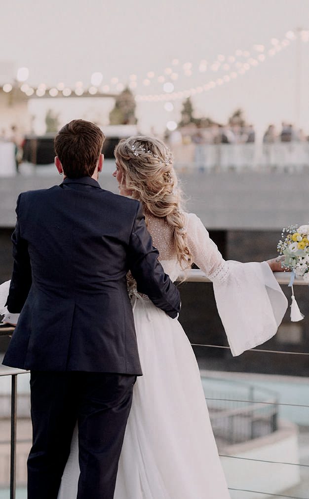 Novios abrazados mirando las vistas desde la azotea