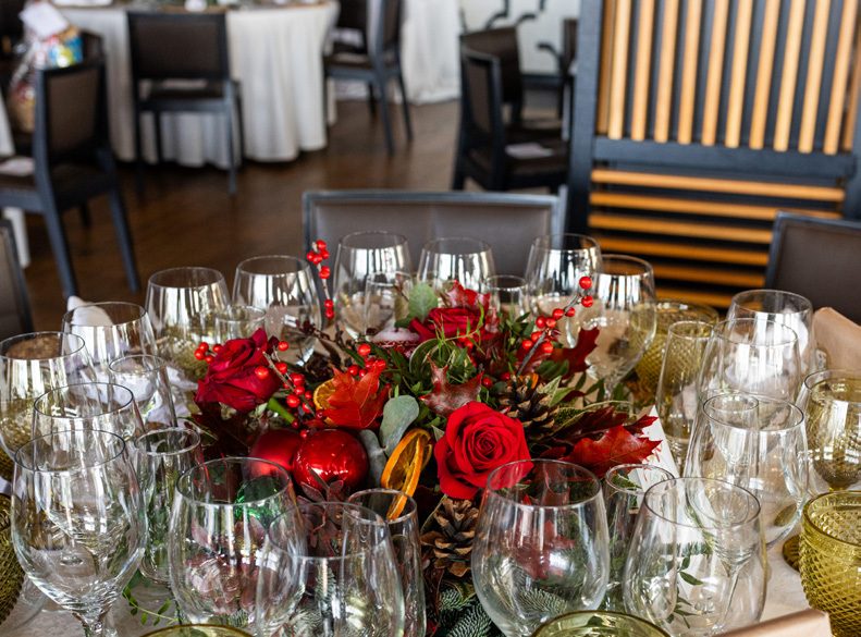 Centro de mesa navideño con rosas rojas y piñas
