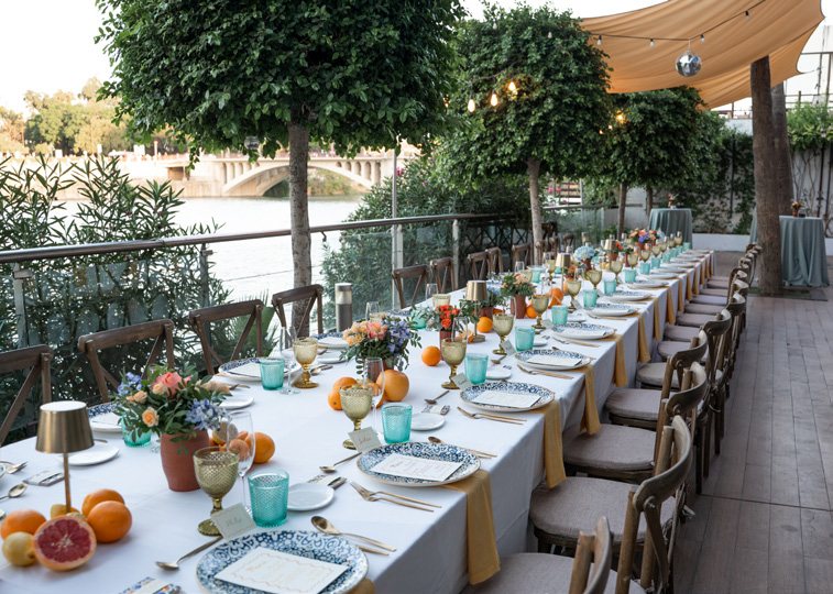 Mesa larga preparada en la terraza junto al río