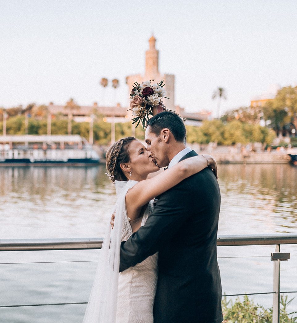Novios besándose junto al Guadalquivir con la Torre del Oro